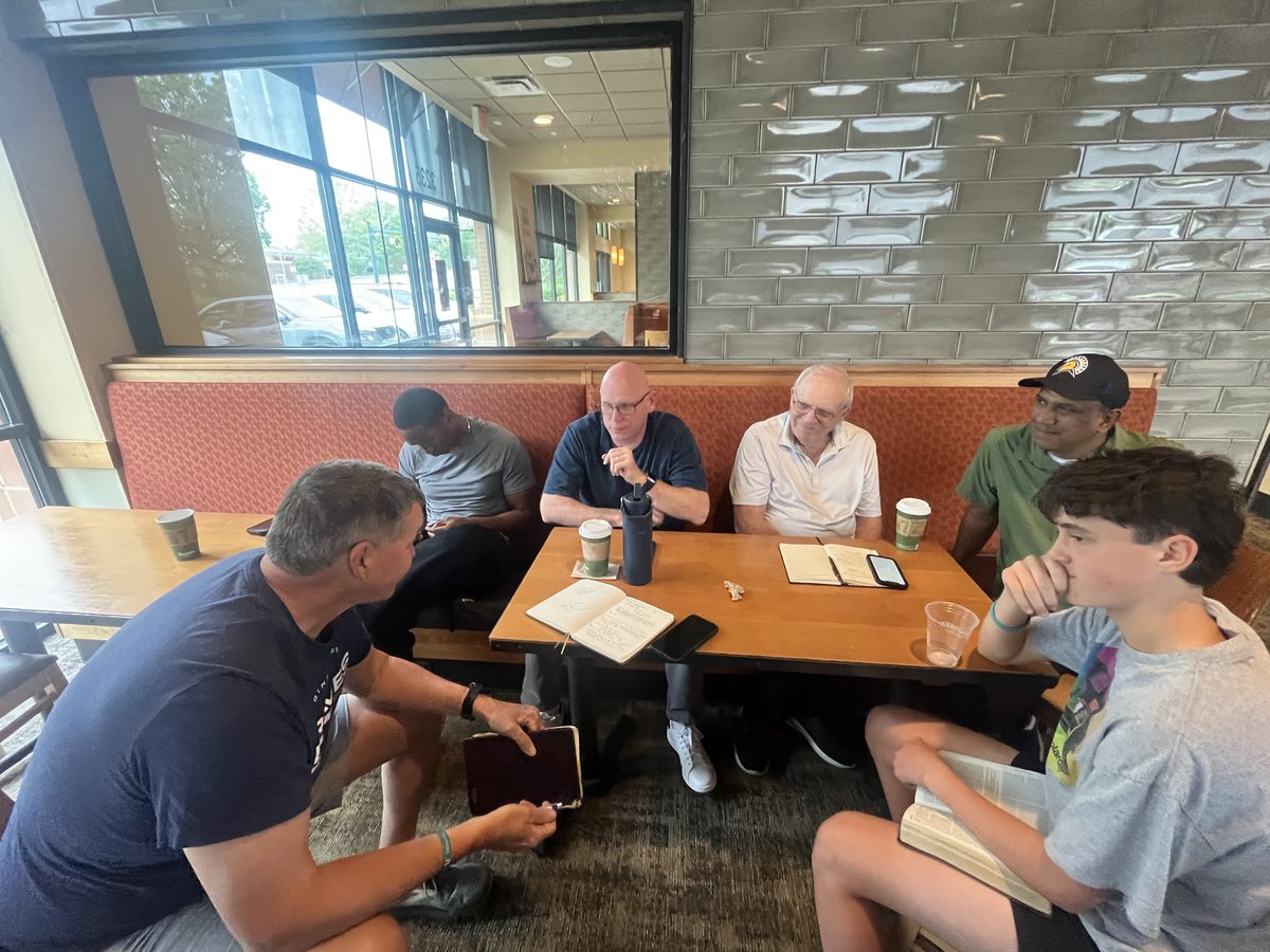 A multicultural group of brothers studying Scripture together at a Panera Bread gathering