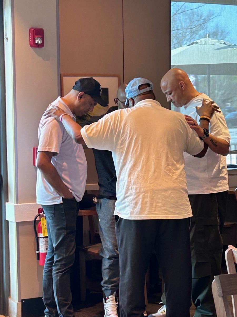 Brothers praying together at a Fellowship of the Fervent gathering